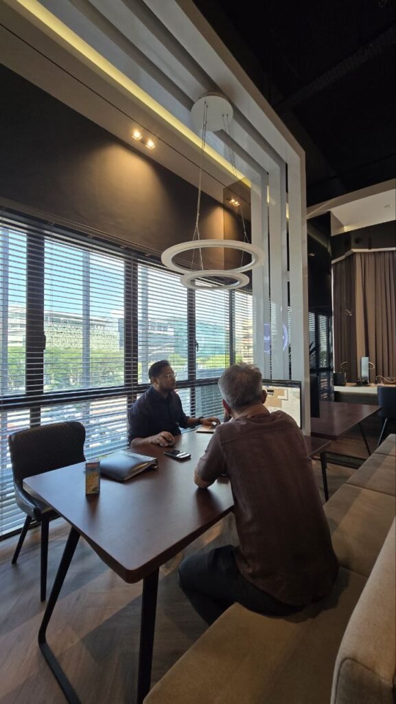 Interior designer reviewing 3D visualisations and floor plan at design studio table