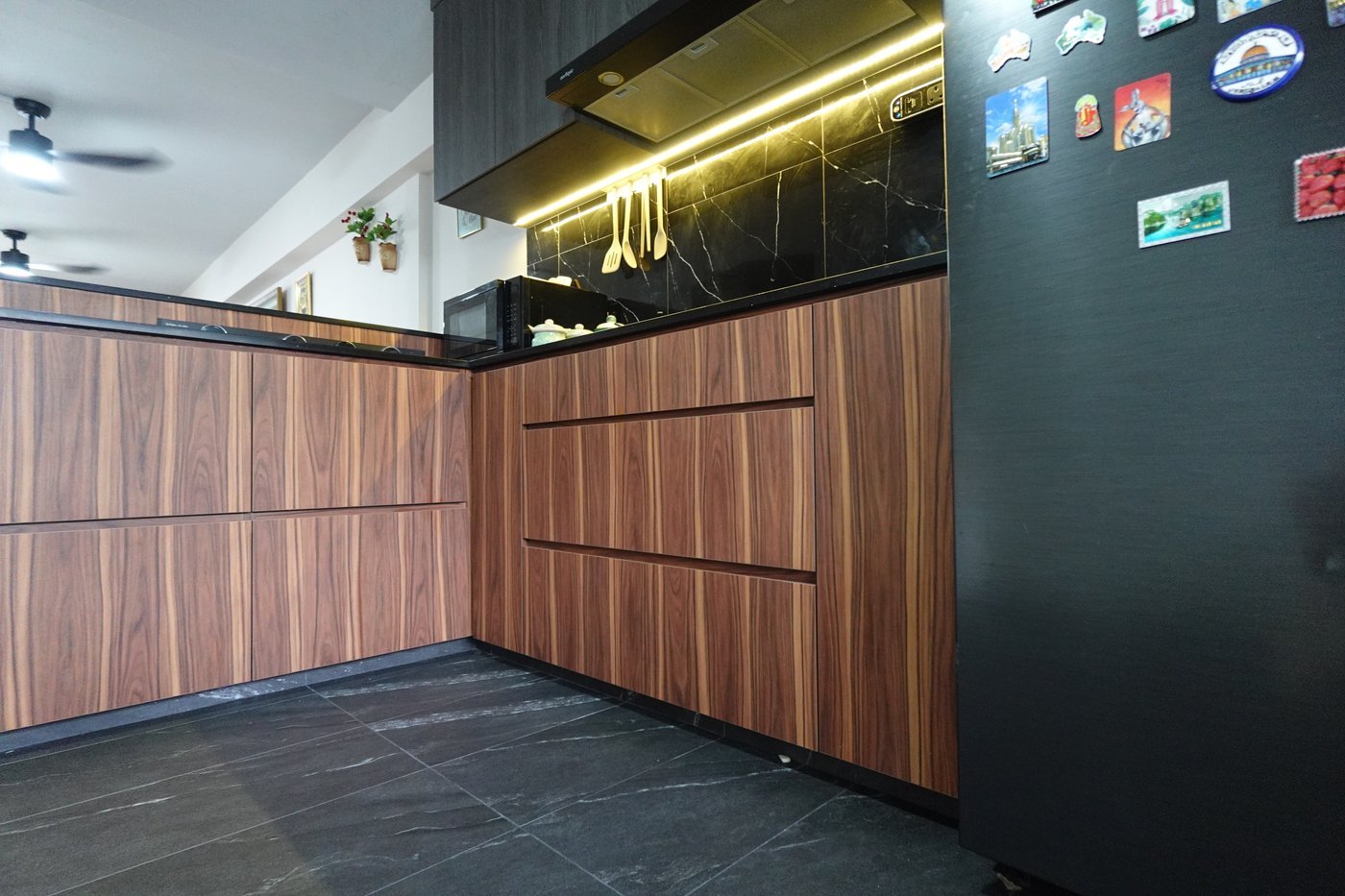 Modern luxury kitchen interior with rich walnut joinery and black marble countertops